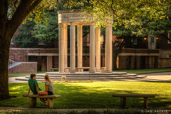 A couple enjoys the beauty of the afternoon light in the Law Quad at SMU.